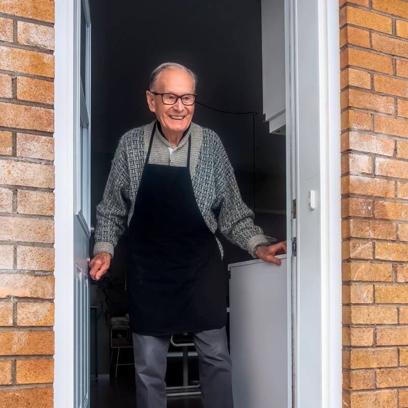 An elderly man at his door