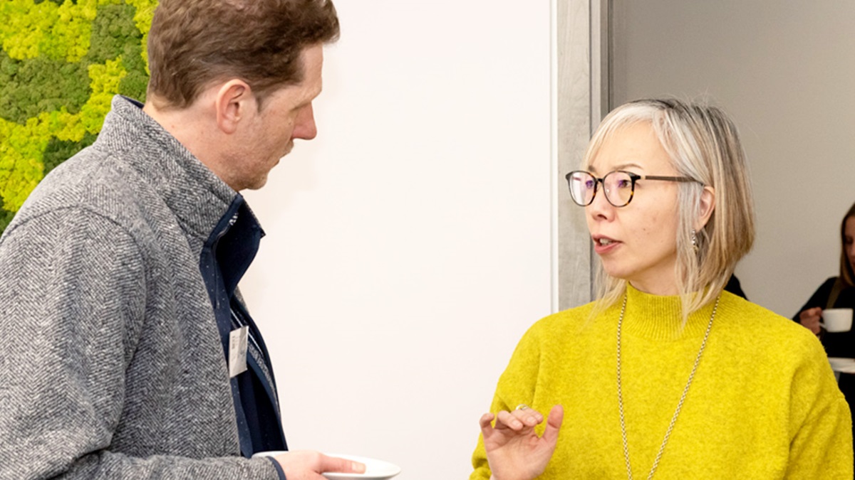 A man and woman talking at an indoor event.