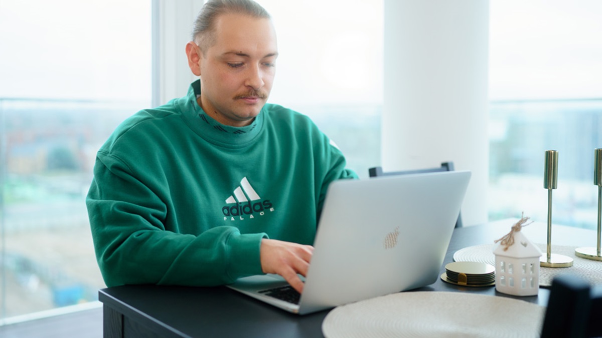 Man in green shirt at laptop