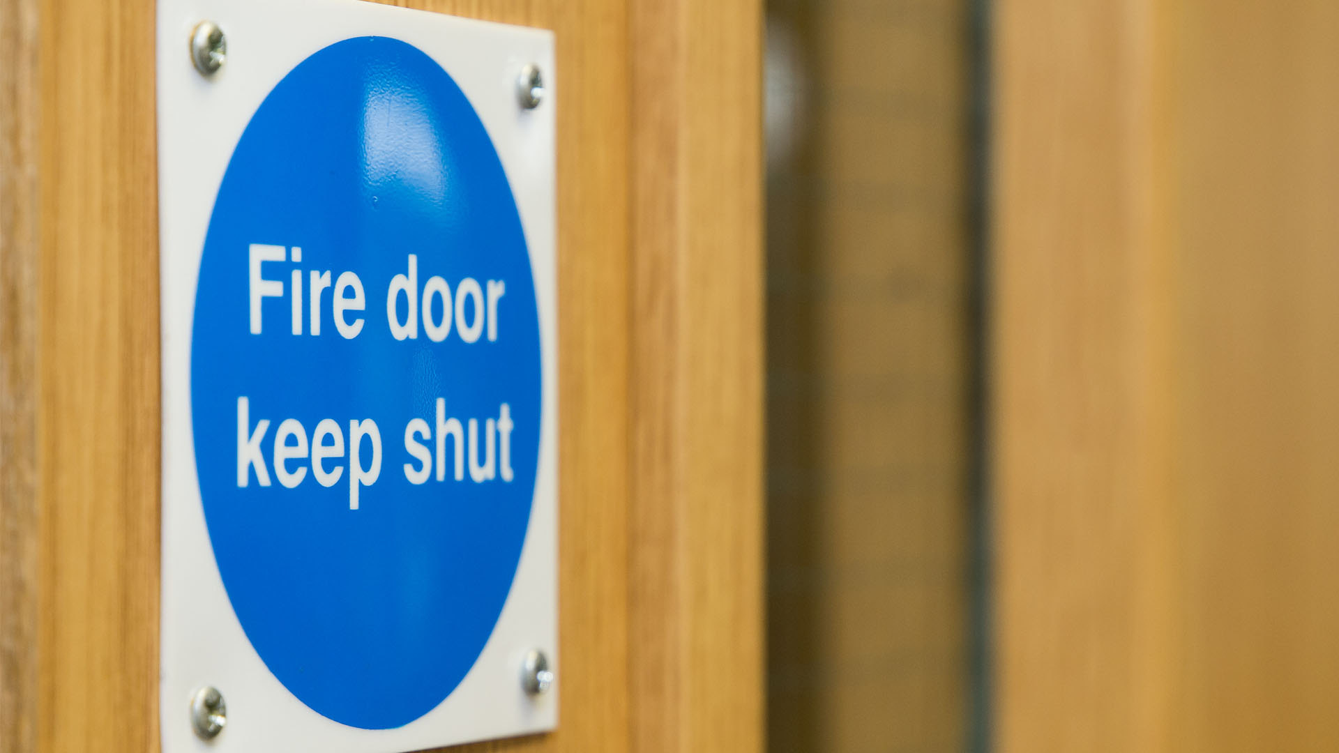 A blue fire door safety sign that says: Fire door keep shut