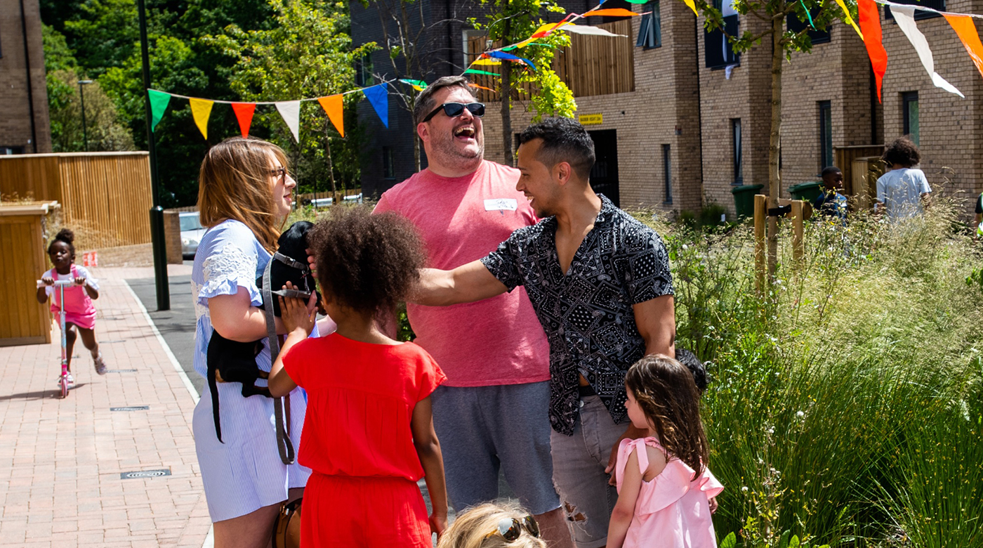 Group of people laughing with colourful bunting in background