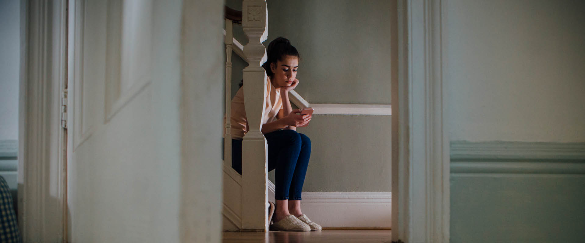 Woman sat on the stairs at home