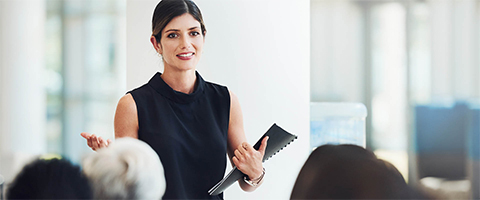 woman standing up and talking at an event or conference