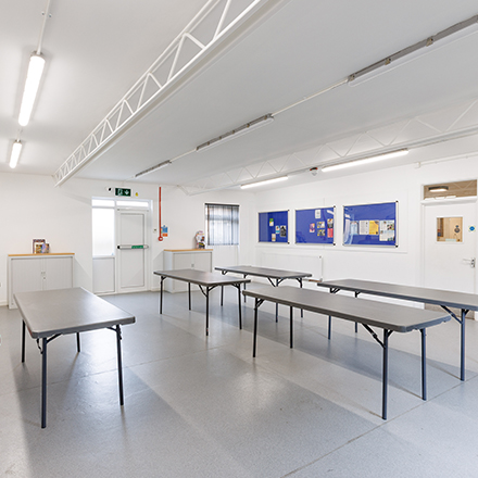 Bright community room with tables arranged for meetings, workshops, or group activities.