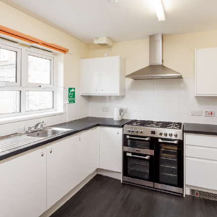 Fully equipped kitchen with cooker, oven, sink, worktops, cupboards, and appliances for preparing food during community activities and events.