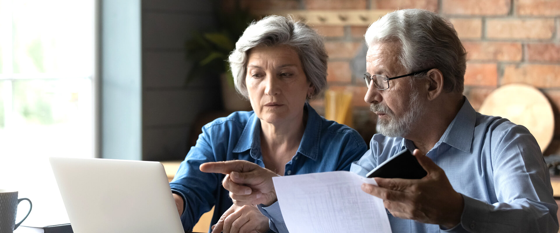 A man and woman looking at a laptop