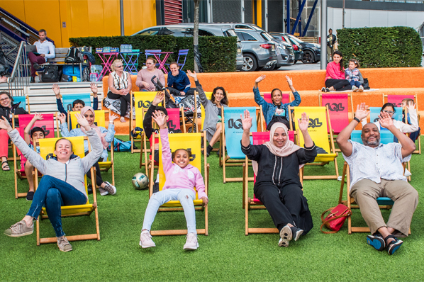 People sat in deck chairs waving