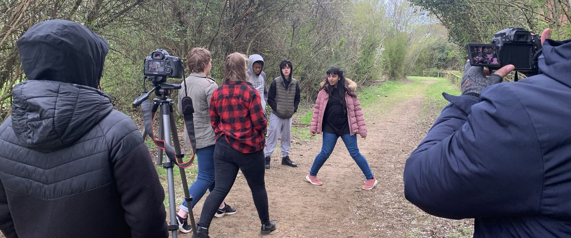 Junior filmmakers filming on footpath