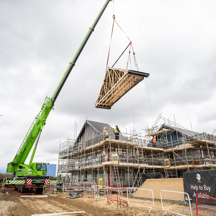 A crane lifting a new home timber frame