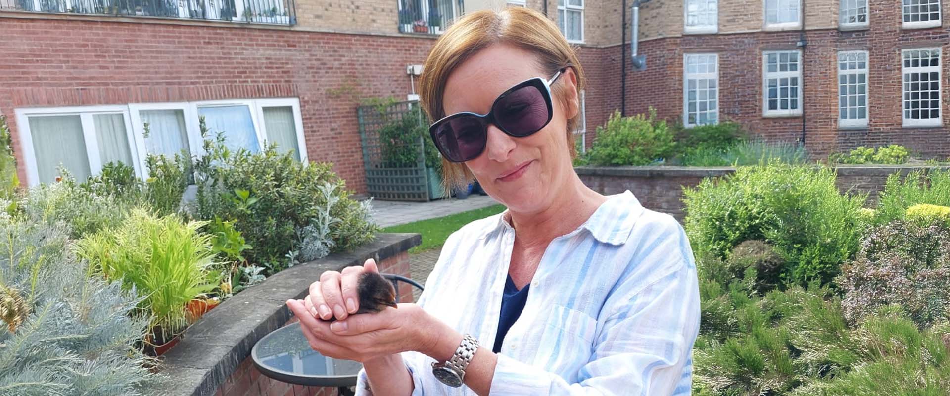 Sarah Millican holding a newly hatched chick at Fiona Gardens