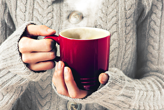 Hand holding a red mug