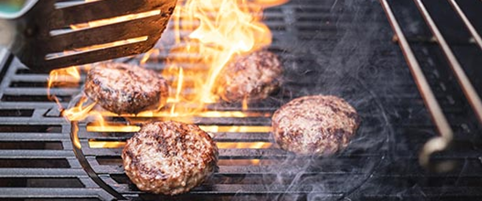 Burgers flaming on a barbeque