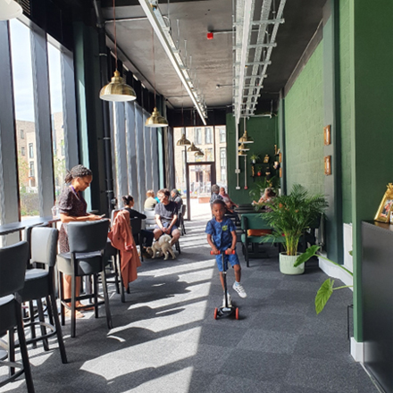 A boy riding a scooter inside Bridget's café 