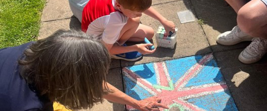 Kids drawing a union jack flag in chalk