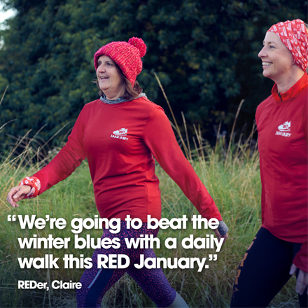 Two women wearing red jumpers walking outside