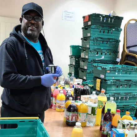 A volunteer preparing food crates for delivery