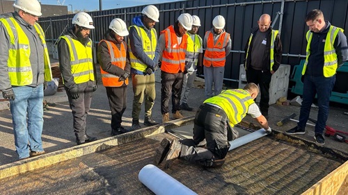  Participants observe a roofing demonstration during Bauder’s hands-on workshop in London.