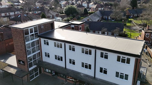 Aerial view of Botherton Court – A drone shot of a three-story residential building with a modern white and brick exterior.