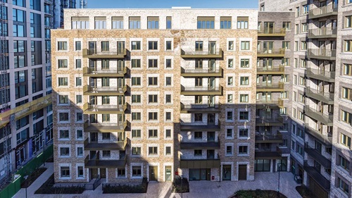 New residential buildings with balconies and brick facades at Brent Cross Town regeneration project.