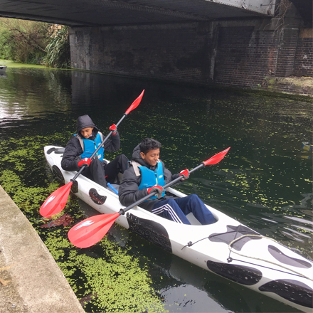 Two boys kayaking on Regent Canal