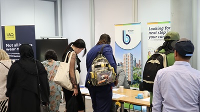 Room full of people at stalls for the job fair