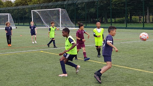 Young people playing football on football pitch