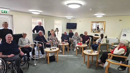 Residents and staff at L&Q's Hanover Way scheme enjoying a community gathering in a lounge, engaging in conversation and activities.