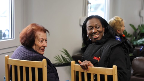 Women smiling and chatting at local indoor gathering