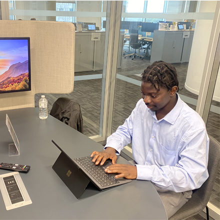 Kaba in an office using a laptop