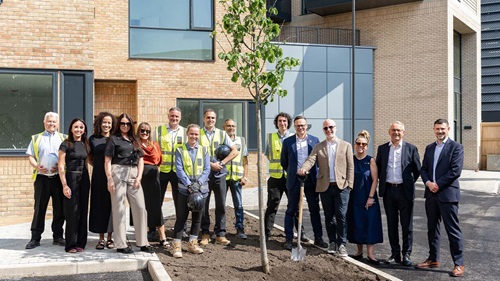 Group of first residents and project leaders at Kew Bridge Rise, standing in front of the new development.