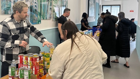 A person looking at tins of food