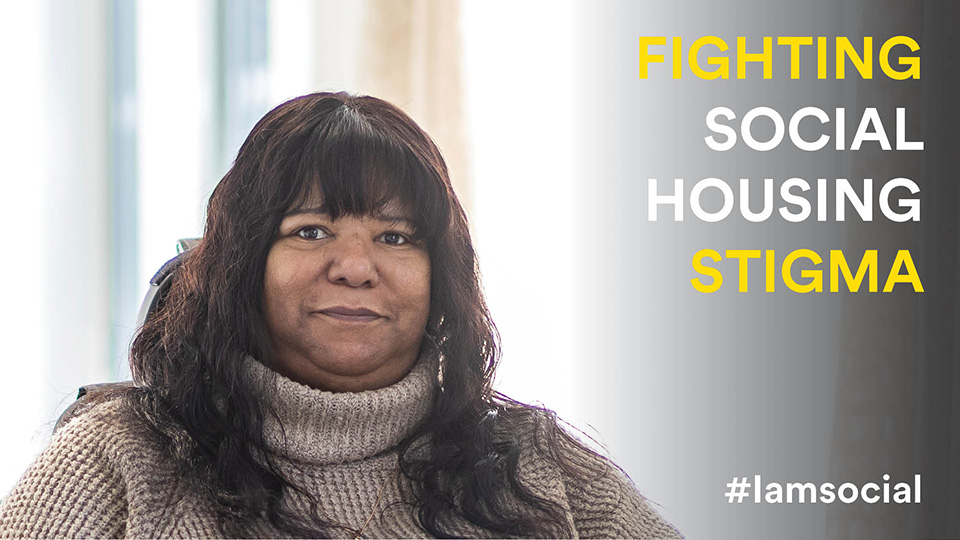 Headshot of Lorna looking at the camera smiling. Lorna had a wooly turtle neck on and and long hair. On the right of the image is text that reads: FIGHTING SOCIAL HOUSING STIGMA #iamsocial