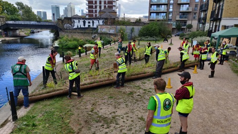A group of volunteers stood next to a canal