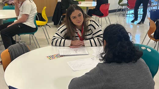 Student working with tutor. Sat around round table.