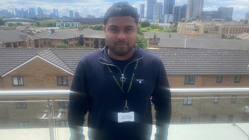 Mehran stood in front of London skyline posing for photo.