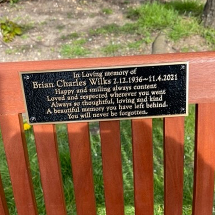 A close-up view of Mr Wilks memorial bench and metal plaque