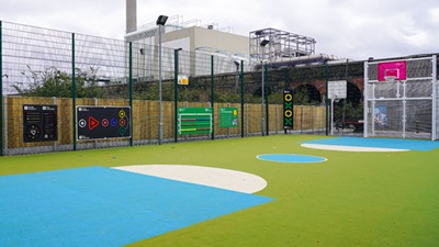 Vibrant outdoor multi-use game area with colorful green, blue, and yellow ground.