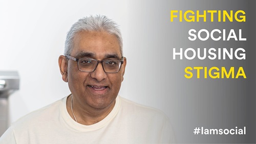 Headshot of Raj looking at the camera smiling. Raj is wearing a white top and wears square glasses. On the right of the image is text that reads: FIGHTING SOCIAL HOUSING STIGMA #iamsocial
