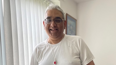 Raj Singh, stroke sufferer, stood up looking into camera happy.