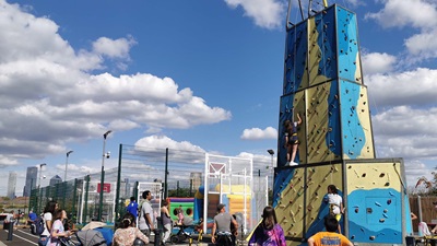 Silwood playground with a large climbing wall and people gathered around