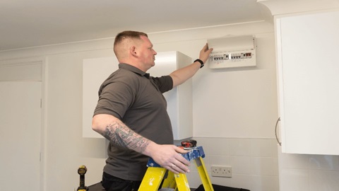 A man looking at an electric switch board