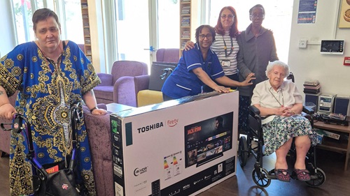 Residents with a new donated smart TV at Verdon Roe Court