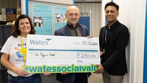 Three people holding a large donation cheque from Wates for £250, made out to The Hygiene Bank