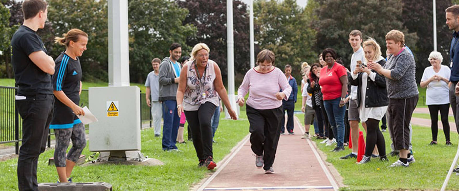 Woman running on track at L and Q Living Sports Day