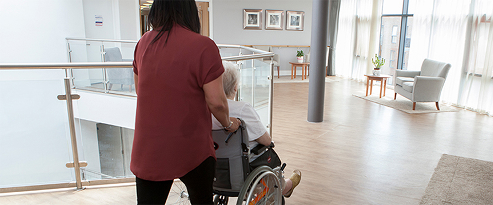 Lady pushing elderly lady in wheelchair