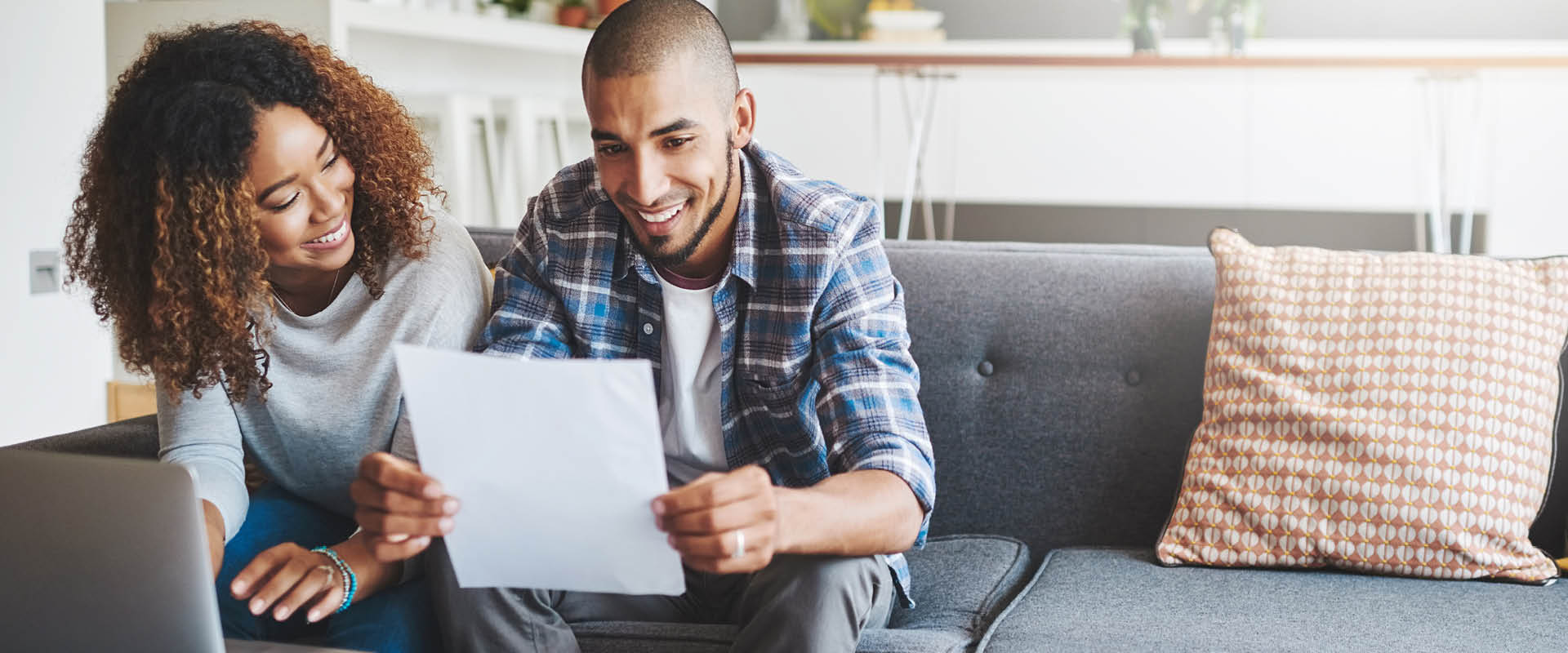 Couple on sofa looking at paper bill