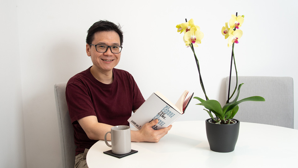 A man reading a book at a table