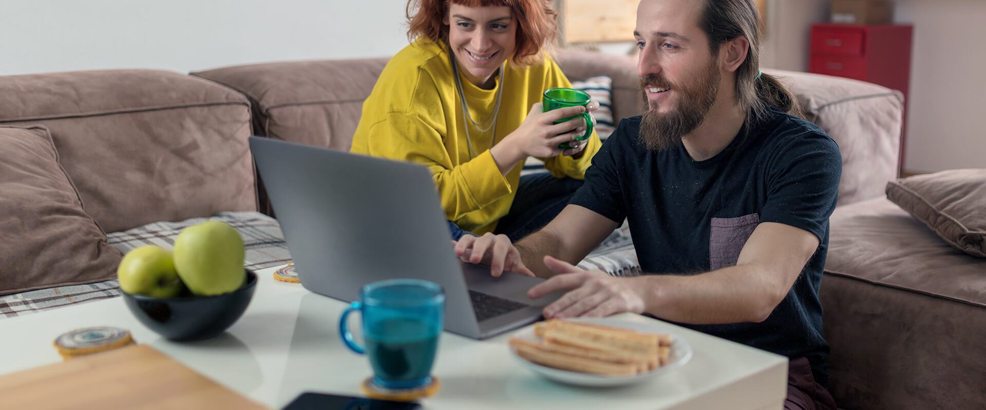 Couple in living room looking at a laptop